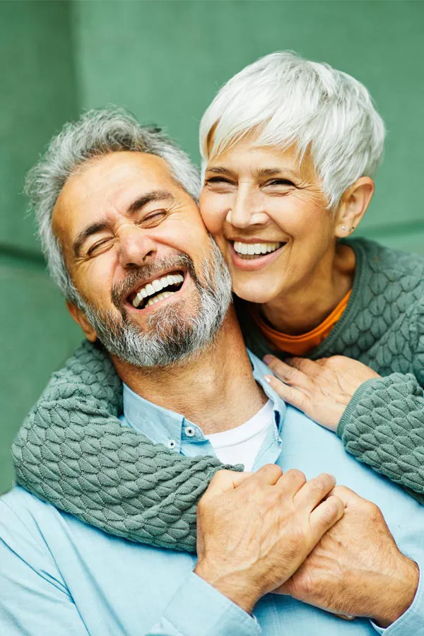 A mature couple embrace on their porch. Schedule Build Your Own IV therapy from Christine Collins, MD in Westside/Beverly Hills.