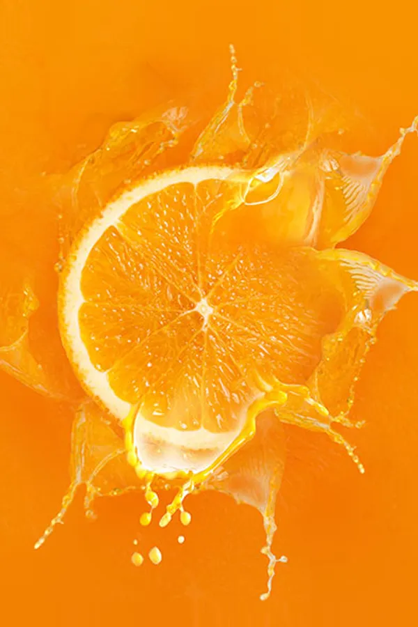 An orange slice dropped into orange juice. Get High Dose Vitaman C IV treatment from Christine Collins, MD in Westside/Beverly Hills.