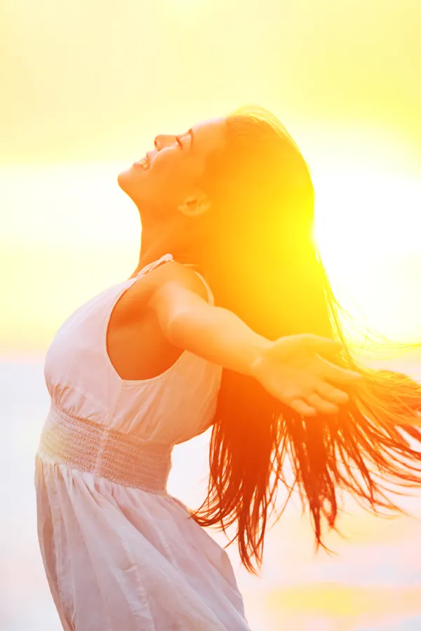 A woman opens her arms to the sky at sunrise. Get Hydration IV Therapy from Christine Collins, MD in Westside/Beverly Hills.