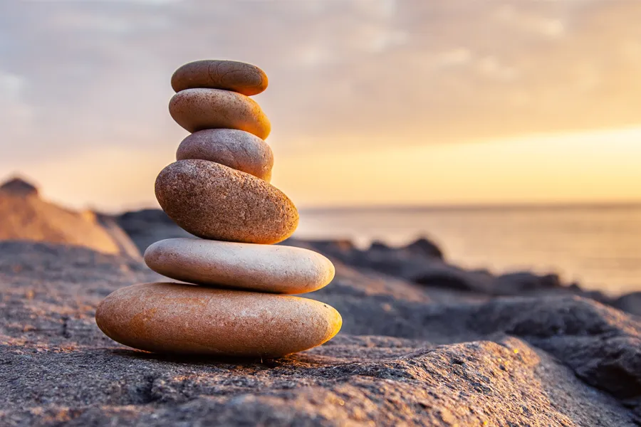 A stack of stones on the beach. Schedule Mineral Vitamin Injection treatment from Christine Collins, MD in Westside/Beverly Hills.