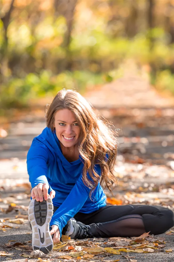 A woman stretches before a trail run. Get IV Therapy for performance recovery relief from Christine Collins, MD in Westside/Beverly Hills.