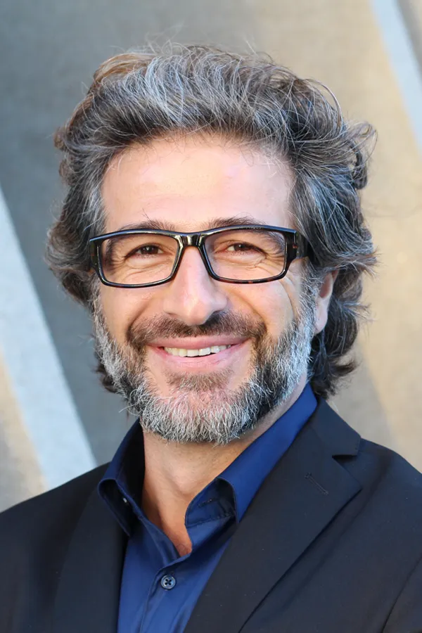 A man with glasses, salt and pepper hair and a beard smiling because he received treatment for andropause and low testosterone from Frank Lanzisera, D.C. in Tampa Bay Metro.