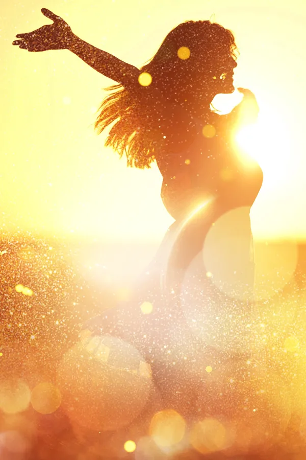 A woman with outstretched arms in the sunset. Get brain mapping treatment from Frank Lanzisera, D.C. in Tampa Bay Metro.