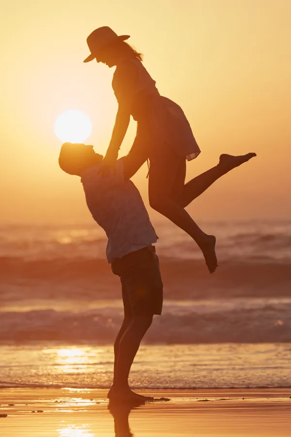 A man lifts a woman on the beach. Get treatment for chronic inflammation from Frank Lanzisera, D.C. in Tampa Bay Metro.