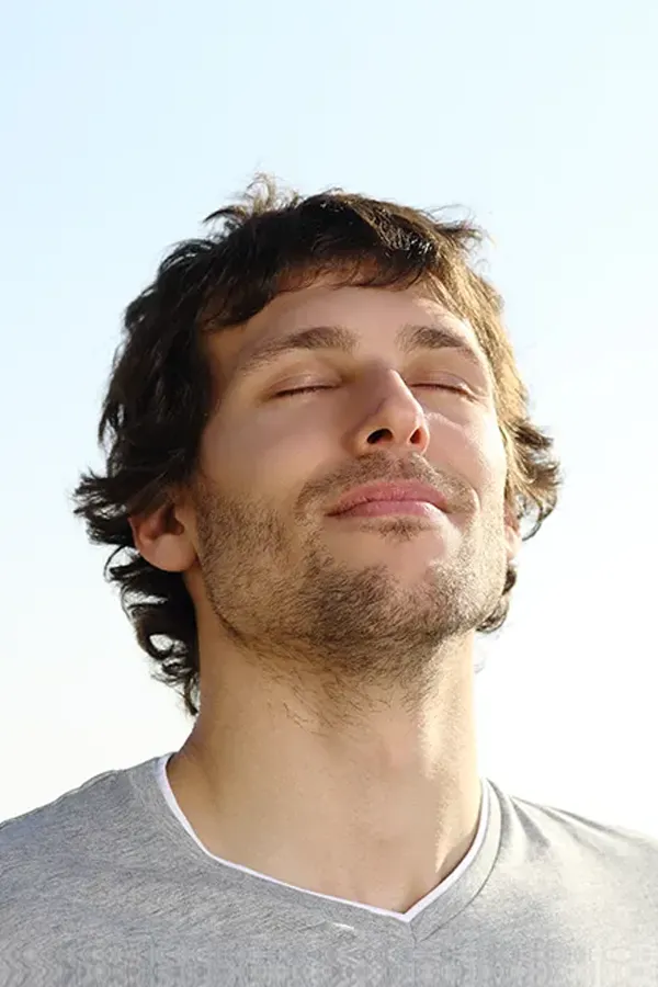 A man with closed eyes and a smile turns his head to the sky calmly. Get treatment for depression from Frank Lanzisera, D.C. in Tampa Bay Metro.