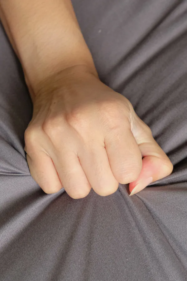 Close-up of a woman's hand grabbing a sheet, indicating sexual pleasure. Get female sexual dysfunction treatment from Frank Lanzisera, D.C. in Tampa Bay Metro.