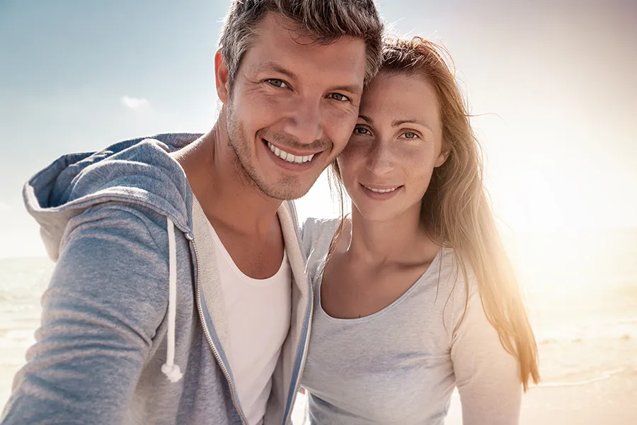A middle-aged couple with youthful skin at the beach. Get IV Therapy for skin health from Frank Lanzisera, D.C. in Tampa Bay Metro.
