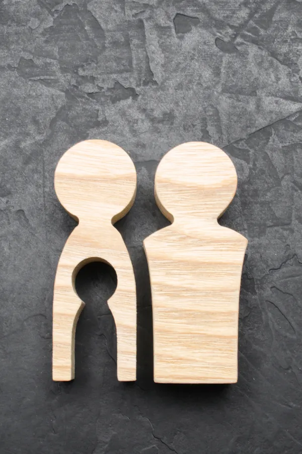 Woodcut figures of a man and woman with a child-shaped area cut out from the woman figure. Get treatment for infertility from Frank Lanzisera, D.C. in Tampa Bay Metro.