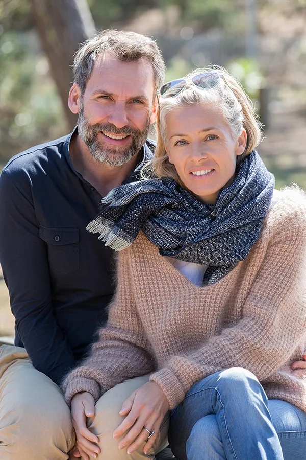 Happy middle-aged couple outdoors wearing cozy fall clothes, smiling calmly. Frank Lanzisera, D.C. is a compassionate IBD specialist in Tampa Bay Metro supporting long-term gut health and symptom relief through functional medicine.