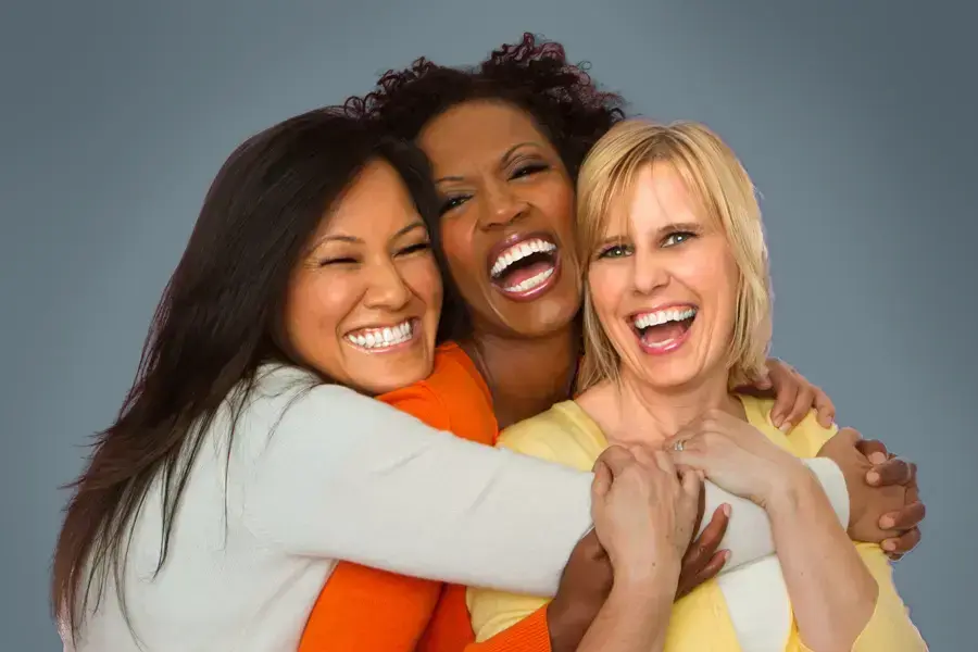An asian, black, and white woman of middle age hug and laugh. Get insulin resistance treatment from Frank Lanzisera, D.C. in Tampa Bay Metro.