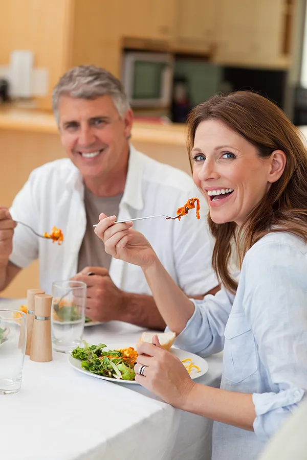 Improve digestion with Frank Lanzisera, D.C.'s Functional Medicine for Leaky Gut Syndrome care in Tampa Bay Metro, featuring a happy couple enjoying a nutritious lunch at home.