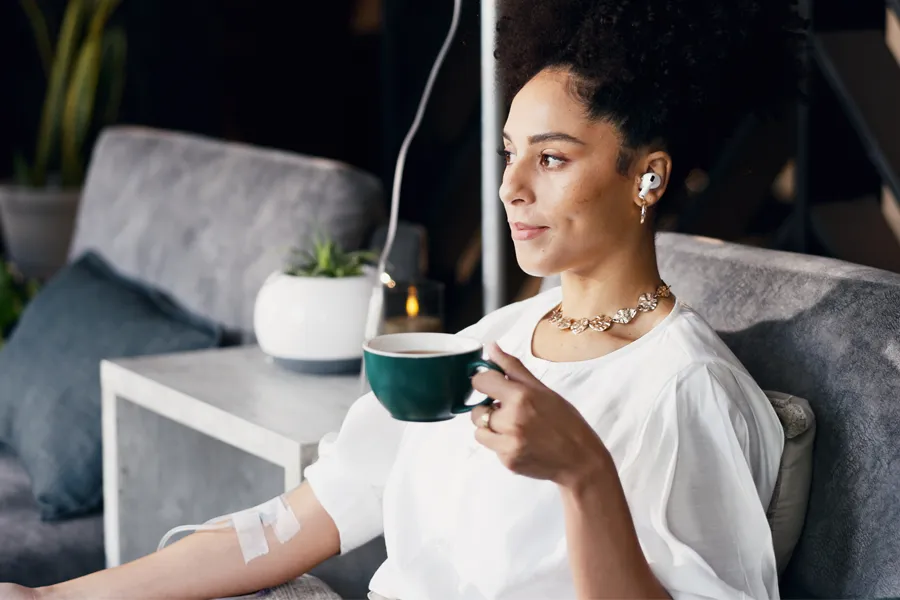 A woman with a cup of tea getting IV therapy. Schedule Brainstorm IV therapy from Frank Lanzisera, D.C. in Tampa Bay Metro.