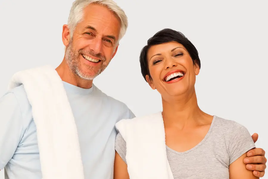 A mature man and woman with towels draped over their shoulders smiling after a work out. Get PEMF Pulsed Electromagnetic Field therapy from Frank Lanzisera, D.C. in Tampa Bay Metro.