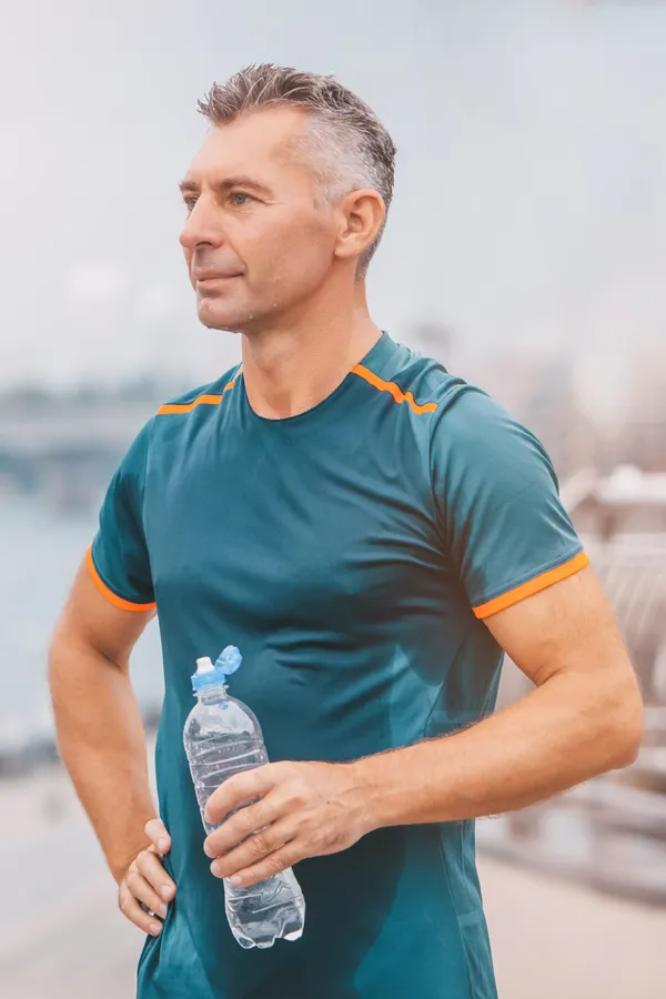 A middle-aged man rehydrates after a hard workout. Get plaquex IV therapy from Frank Lanzisera, D.C. in Tampa Bay Metro.
