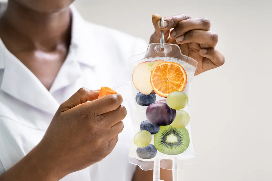 A clinician holds an IV bag full of healthy berries. Get Reboot IV therapy from Frank Lanzisera, D.C. in Tampa Bay Metro.