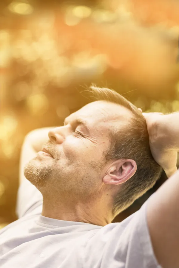 A man relaxes in the sun. Get red light therapy from Frank Lanzisera, D.C. in Tampa Bay Metro.