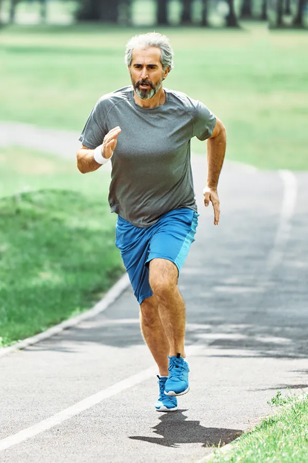 An older man in gym clothes runs on a trail having had successful exosome treatment for knee pain from Frank Lanzisera, D.C. in Tampa Bay Metro.