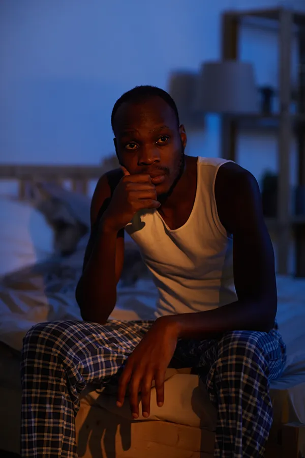 A man sits on the edge of his bed concerned that he can't sleep. Get treatment for sleep disorders from Frank Lanzisera, D.C. in Tampa Bay Metro.